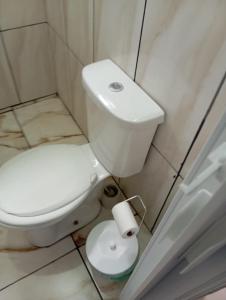 a bathroom with a toilet and a roll of toilet paper at Apartamentos-8-3-6 - Pousada Itapetininga in Itapetininga