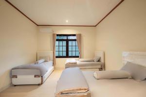 a large room with two beds and a window at Imah Budi Luhur in Bandung