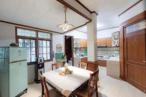 a kitchen with a table and a refrigerator at Imah Budi Luhur in Bandung