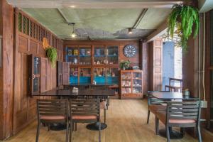 a dining room with a table and chairs and a clock at P1 House Phitsanulok in Phitsanulok