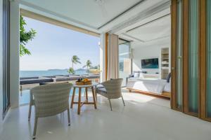 a bedroom with a bed and a table and chairs at Bandara Pool Villas, Phuket in Panwa Beach