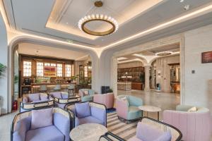a lobby with blue and pink chairs and tables at Mercure Beijing City Center in Beijing