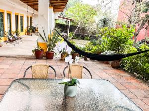 a hammock on a patio with a table and chairs at Shanti Home in Tepoztlán