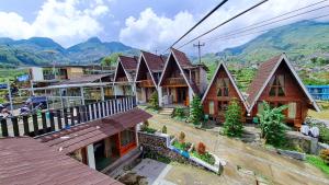 a group of houses with mountains in the background at Zaada Villa Dieng Syariah By Travelink in Kejajar