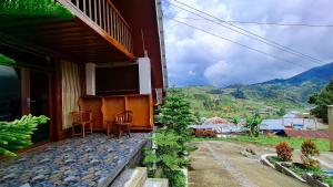 a balcony of a house with a table and chairs at Zaada Villa Dieng Syariah By Travelink in Kejajar