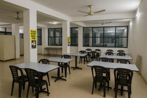 a row of tables and chairs in a cafeteria at Home Nest in Anand