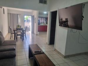 ein Wohnzimmer mit einer Couch und einem Fernseher an der Wand in der Unterkunft Libano in Manuel F. Martínez + 5 Fotos
