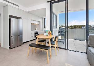 a kitchen and dining room with a table and chairs at Aqua Cove - Marina Escape in Shellharbour