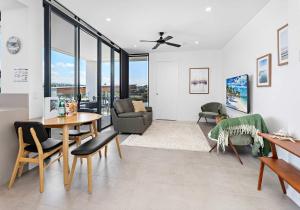 a living room with a table and chairs at Aqua Cove - Marina Escape in Shellharbour