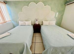 two beds sitting next to each other in a room at Aibilins in Veracruz