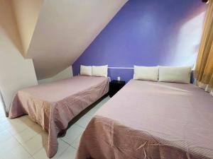 two beds sitting next to each other in a room at Aibilins in Veracruz