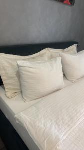 a bed with white pillows on top of it at Полёт in Chişinău