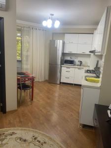a kitchen with white cabinets and a table with a tableablish at Полёт in Chişinău +90 photos