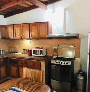 a kitchen with a stove and a microwave at Casa estilo campestre in Chitré