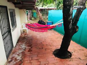 a hammock on a patio next to a tree at Casa estilo campestre in Chitré