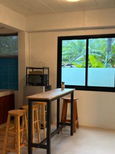 a kitchen with a table and stools in front of a window at Lakehouse in the Old Rainforest in Ko Phangan
