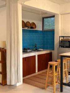 a kitchen with blue tiles and a table and chairs at Lakehouse in the Old Rainforest in Ko Phangan +8 photos