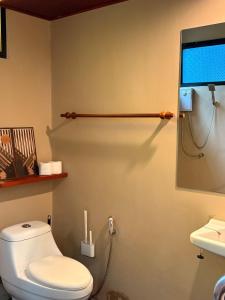 a bathroom with a toilet and a monitor on the wall at Lakehouse in the Old Rainforest in Ko Phangan