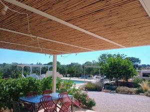 a patio with a blue table and chairs under a wooden umbrella at Trullo del Sol in Ceglie Messapica