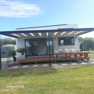 a pavilion with a picnic table and a deck at Gorgeous private tiny home in  Waipukurau