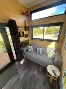 a living room with a couch and a window at Gorgeous private tiny home in  Waipukurau +16 photos