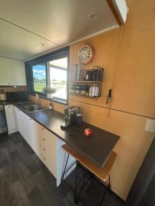 a kitchen with a counter and a clock on the wall at Gorgeous private tiny home in  Waipukurau
