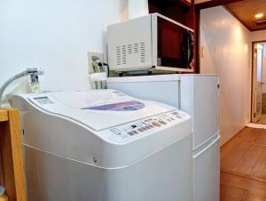 a washing machine with a microwave on top of it at Our-Turn Traditional Machiya near Heian Shrine in Kyoto