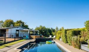a backyard with a swimming pool and a house at Mountviews Lodge in Taupo