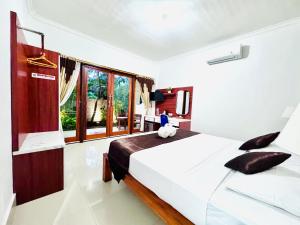 a bedroom with a large white bed and a window at Chillhouse Lembongan in Nusa Lembongan +51 photos