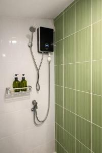 a shower in a bathroom with a television on the wall at Little Mountain Nest in Haad Pleayleam