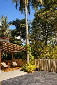 a patio with a wooden shelter and a palm tree at Little Mountain Nest in Haad Pleayleam