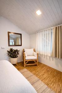 a bedroom with a bed and a chair and a mirror at Little Mountain Nest in Haad Pleayleam