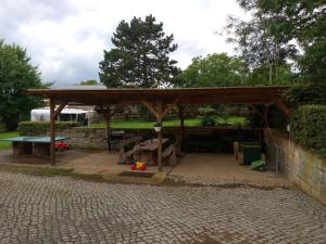 a wooden pavilion with a playground in a park at Ferienwohnung Kälberstall in Reinhardtsdorf