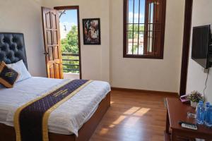 a bedroom with a bed and a table and a television at Window 2 Hotel in Kon Tum