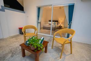 two chairs and a table in a room with a bed at BK Villa in Hikkaduwa