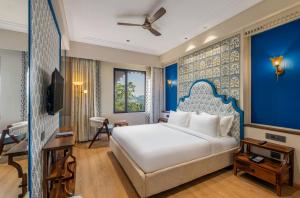 a bedroom with a large bed and a blue wall at Acacia Somgarh Udaipur in Udaipur +30 photos