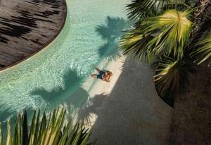 a man laying on the beach in a pool of water at Kumbara Oasis Lombok in Kuta Lombok