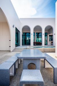 a row of benches in a building with windows at Gam-Hom Poolvilla ชะอำ in Ban Hua Phrong