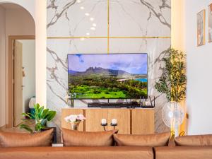 a living room with a flat screen tv on a wall at Gam-Hom Poolvilla ชะอำ in Ban Hua Phrong
