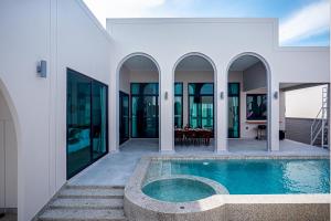 an external view of a house with a swimming pool at Gam-Hom Poolvilla ชะอำ in Ban Hua Phrong