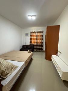 a small bedroom with a bed and a couch at Bacolod Transient Home in Bacolod +51 photos
