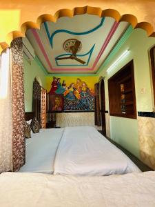 a bedroom with a bed with a painting on the ceiling at The Rajputana Heritage in Jodhpur +3 photos