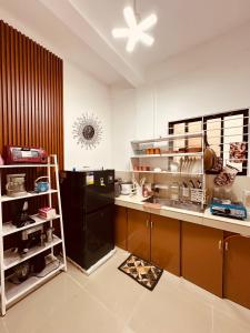 a kitchen with a counter and a black refrigerator at Bacolod Transient Home in Bacolod