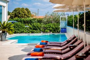 a group of lounge chairs next to a swimming pool at Apartments Kimi in Rovinj