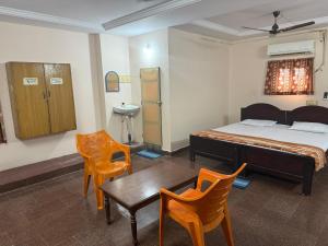 a bedroom with a bed and a table and chairs at Surya lodge in Rāzole