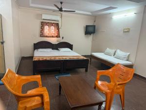 a room with a bed and two chairs and a table at Surya lodge in Rāzole
