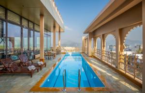 a swimming pool on the balcony of a building at Acacia Somgarh Udaipur in Udaipur