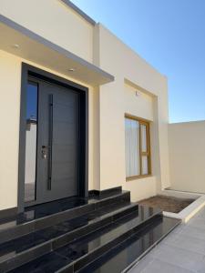 a house with a black door on the side of it at Istrahtmas2 in Barka