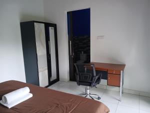 a bedroom with a bed and a desk and a chair at Giri Homestay in Amed