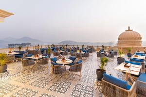 a restaurant with tables and chairs on a roof at Acacia Somgarh Udaipur in Udaipur